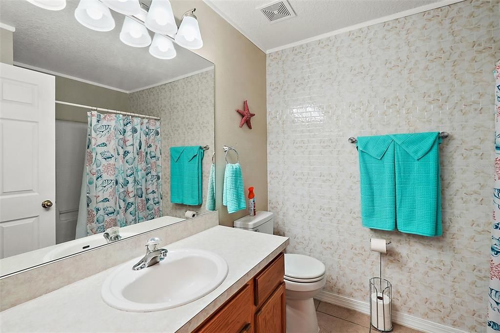 Guest bathroom is a tub + shower combo