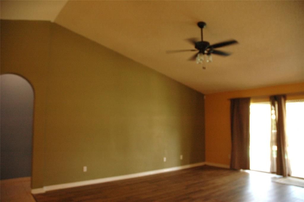 Great room has ceiling fan with vaulted ceiling