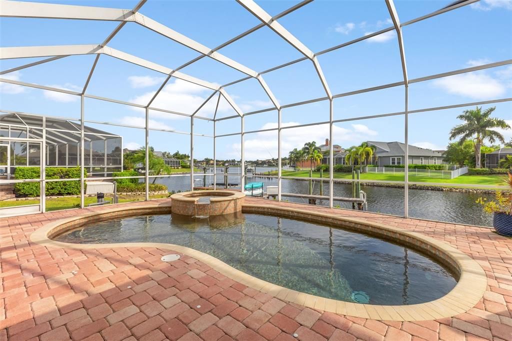 Beautiful heated pebble tech pool, spa with gorgeous pavers and view to waterfront