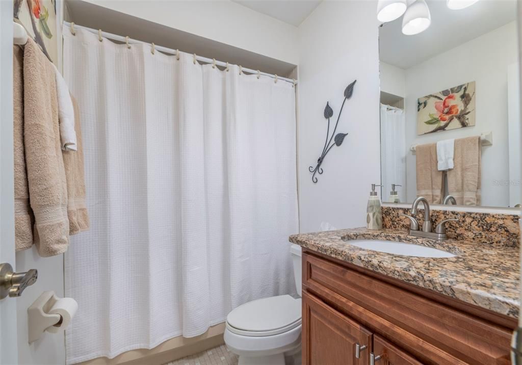 Guest bathroom with new vanity and granite counter. This bath has a tub/shower combo.