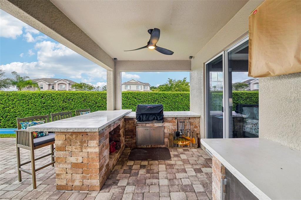 The immaculate landscaping combined with the extensive paver patio, CUSTOM POOL - BUILT 2024, OUTDOOR KITCHEN with BAR SEATING and FIREPIT all FENCED for added privacy gives you a backyard dreams are made of!