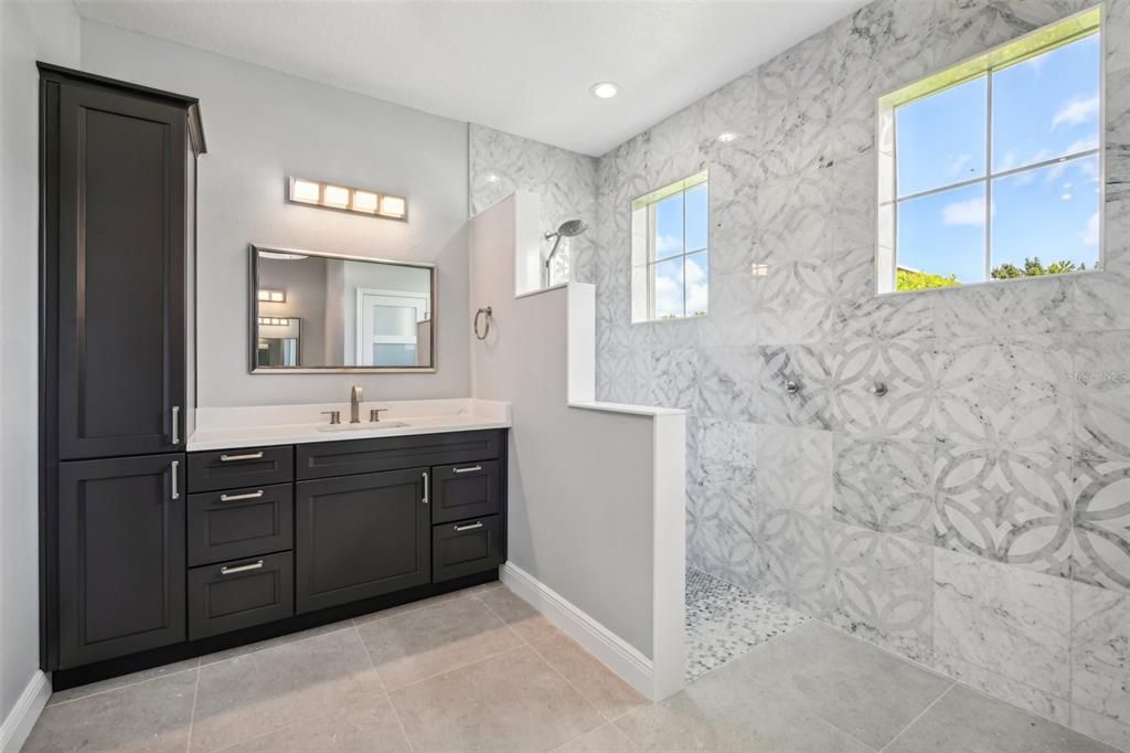 No detail was missed in the private bath from the rich modern cabinetry, thoughtful lighting and CUSTOM TILED SHOWER, you have everything you need to start and end your day with ease.