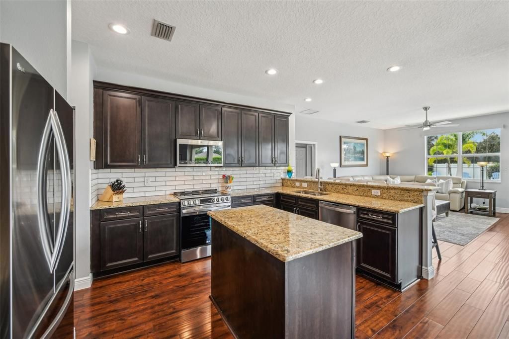 The family chef will appreciate the NEW STAINLESS STEEL APPLIANCES (2023), chic subway tile backsplash and under cabinet lighting (2024), ample cabinet and counter space, including a PREP ISLAND, recessed lighting and for casual dining your choice of a breakfast bar or nook with direct access to the lanai!