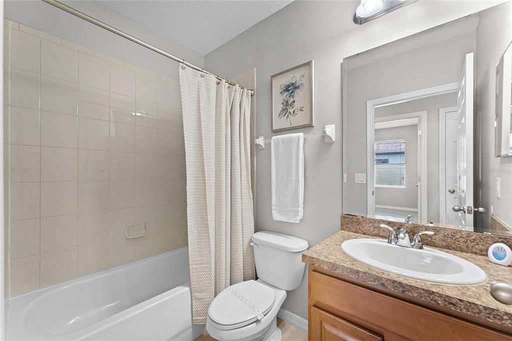 Guest bath attached to Guest bedroom 1 near the front of the home