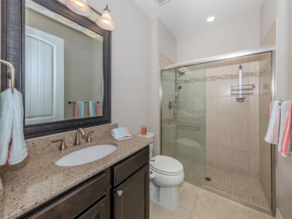 The second full bath with glass enclosure is shared by the second and third bedrooms