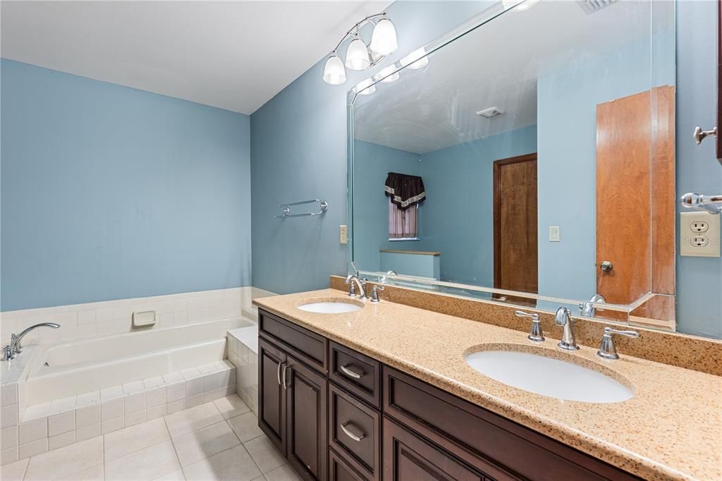 Owners ensuite bathroom featuring dual sinks, a garden tub, and walk-in shower.