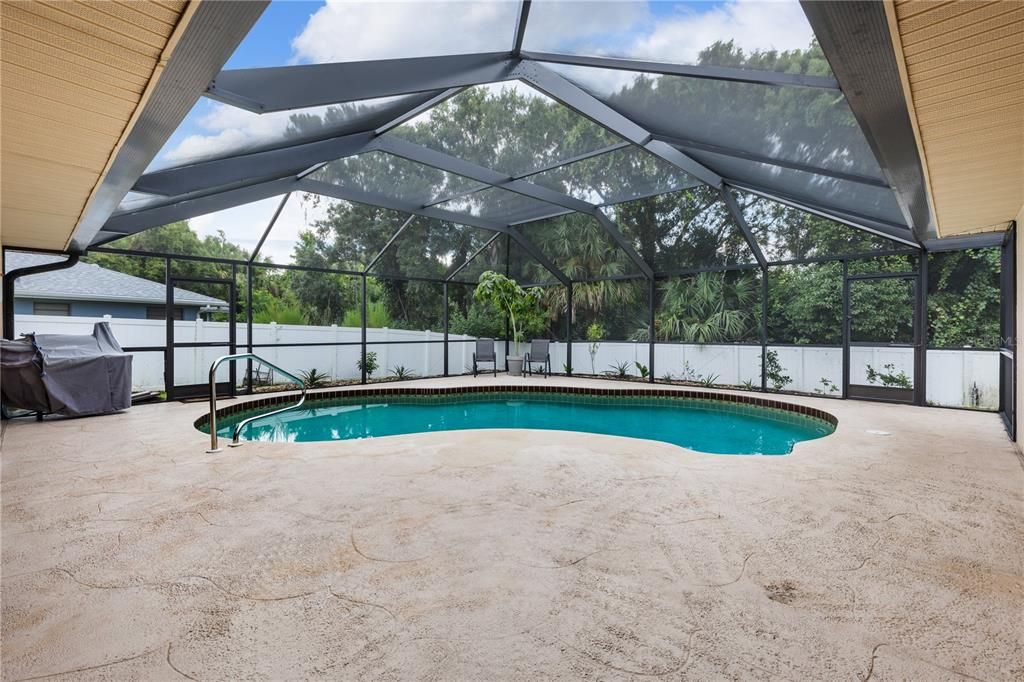 Spacious screened-in lanai featuring a headed saltwater pool, and views of the fenced-in back yard.