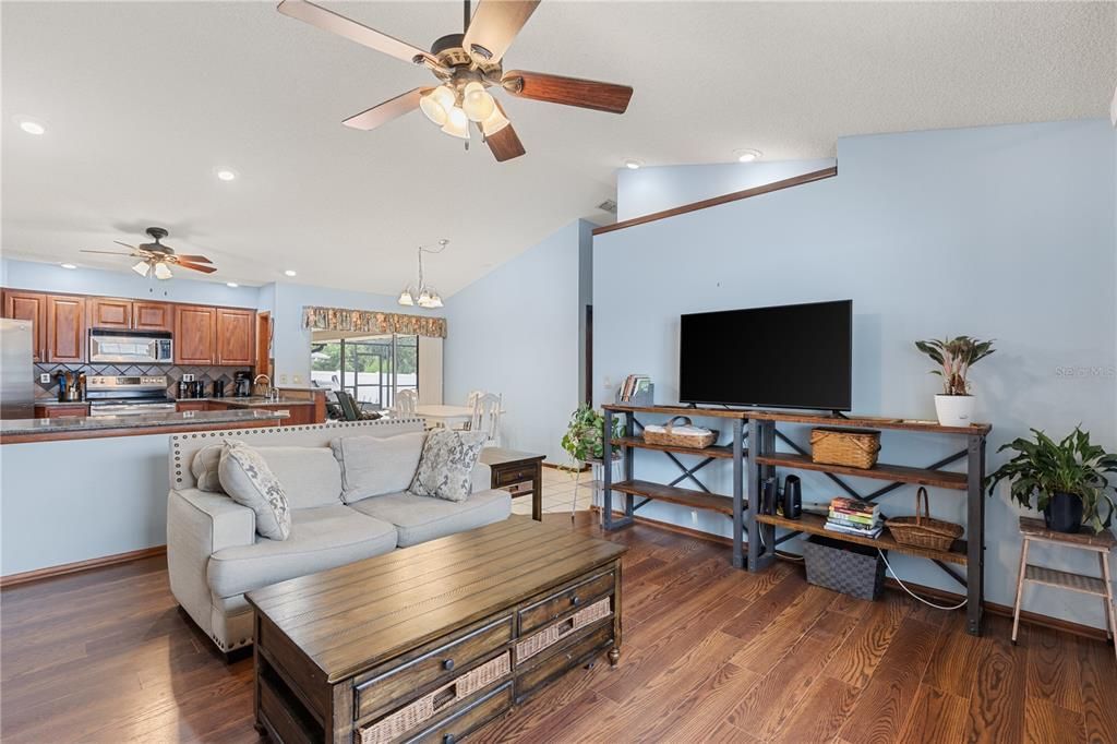 Living Room off the kitchen featuring a large window, and wood flooring.