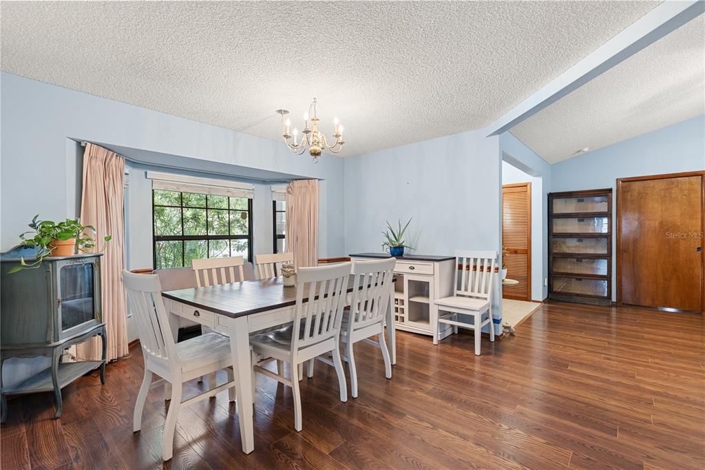 Dining room off the front foyer and family room featuring a large window, and wood flooring.