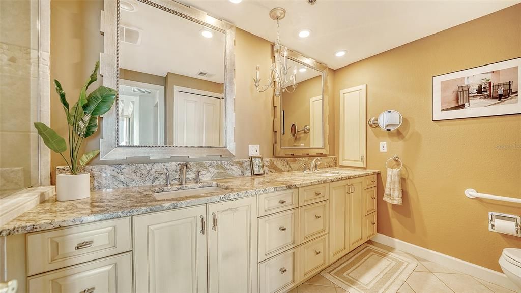 Ensuite bath in primary bedroom has dual sinks and a walk-in shower and linen closet.