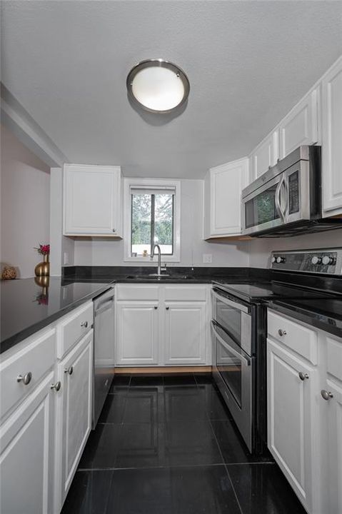 White cabinets and stainless steel appliances and bright window