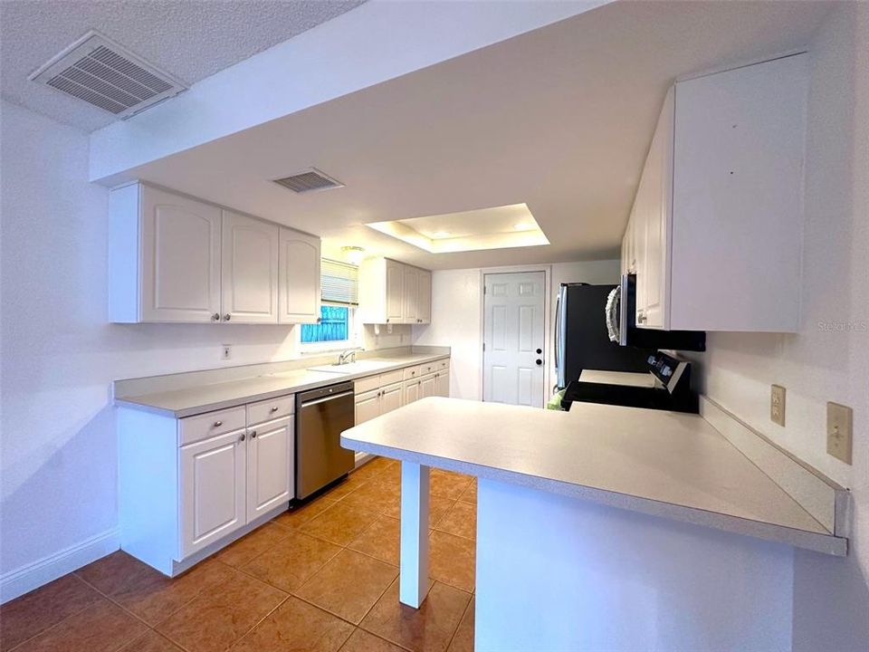 Kitchen with eating bar at counter height and new appliances