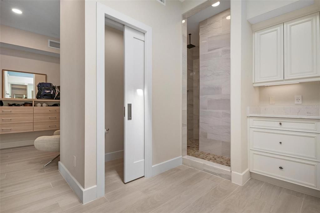 Primary ensuite bathroom with dual vanities and walk in shower