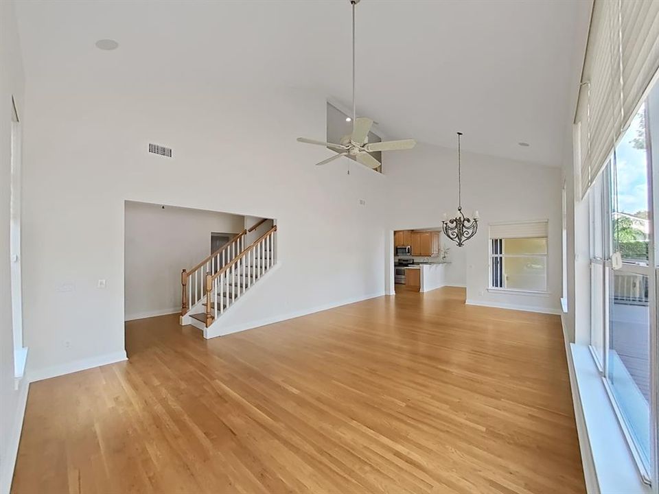 from great room with vaulted ceiling looking to kitchen and stairs