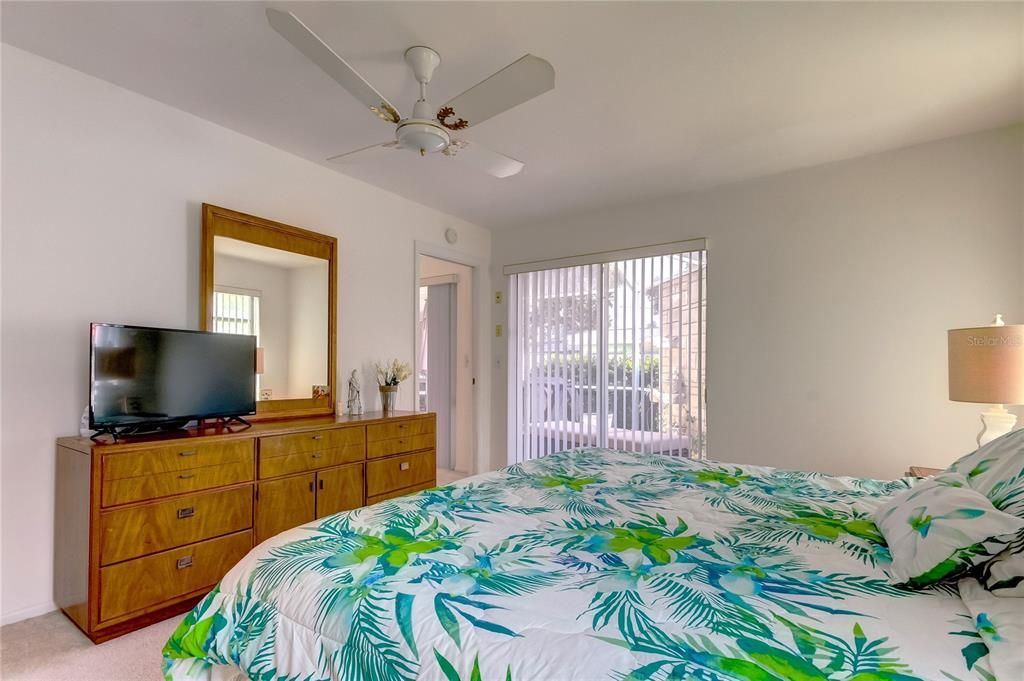 Primary bedroom with slider doors to screened patio with water feature