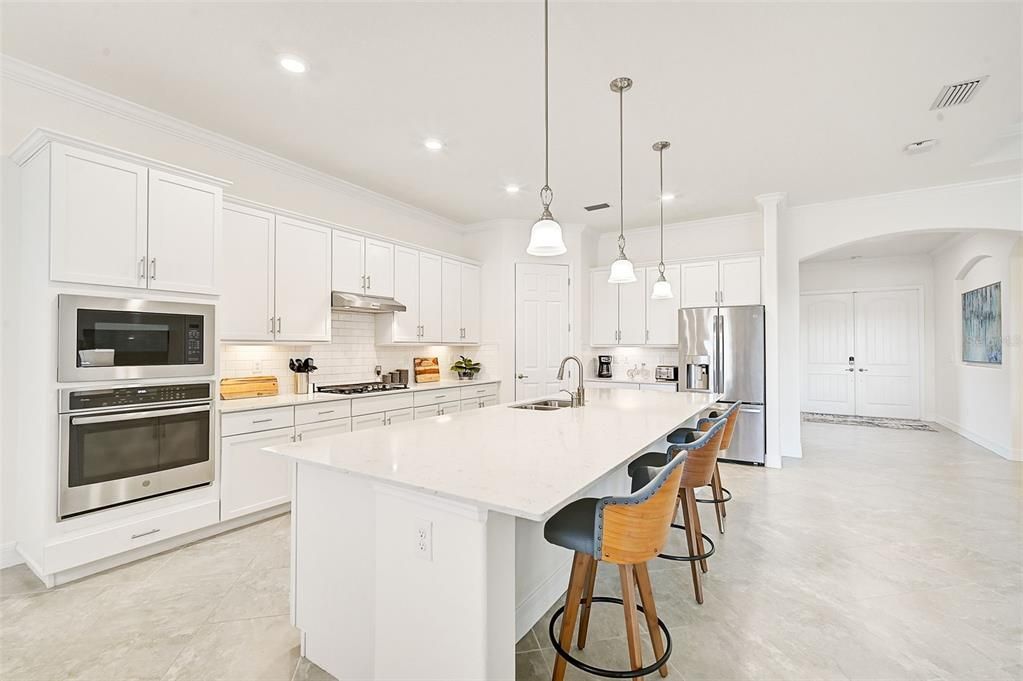 kitchen w/ quartz countertops, gas cooking, walk-in pantry.