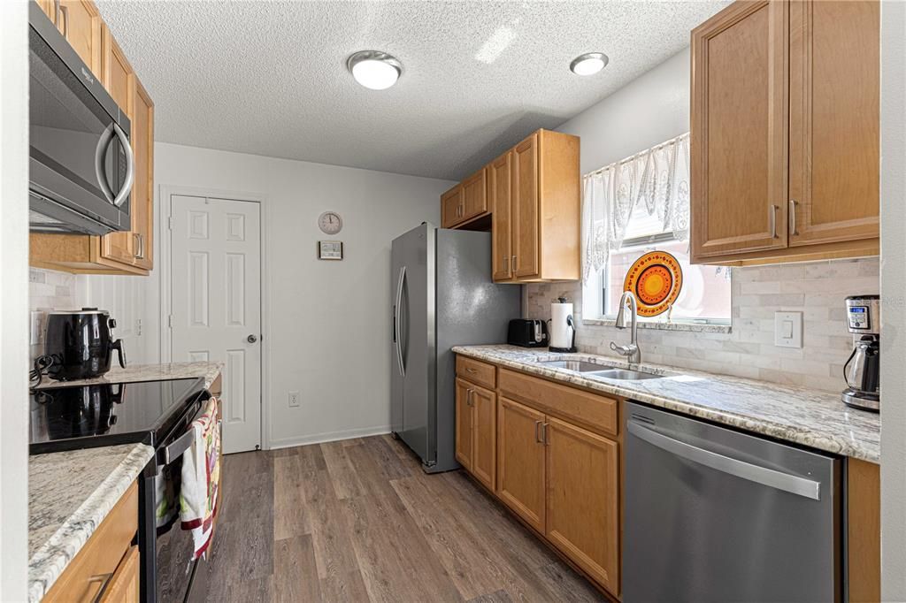 RECENTLY RENOVATED KITCHEN W/ SS APPLIANCES, NEW CABINETS, GRANITE COUNTERS, TILED BACKSPLASH AND NEW LIGHTING COMPLETE THE RENOVATION