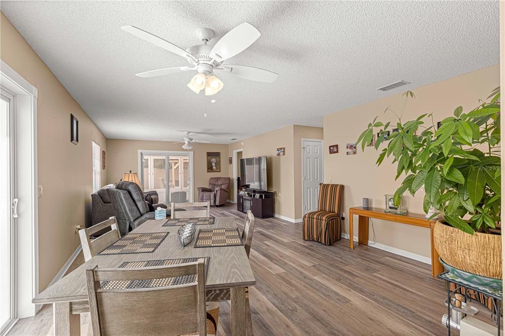 NEW LVP FLOORING, NEW CEILING FANS WITH LIGHT KITS AND A NEW SLIDING DOOR WITH BLIND INSERTS LEADING FROM THE LIVING ROOM TO THE ENCLSOED LANAI