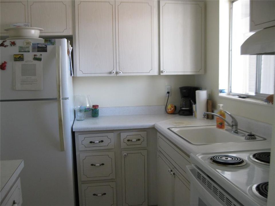 KITCHEN HAS REFRIGERATOR, RANGE AND EXTRA CABINETRY.