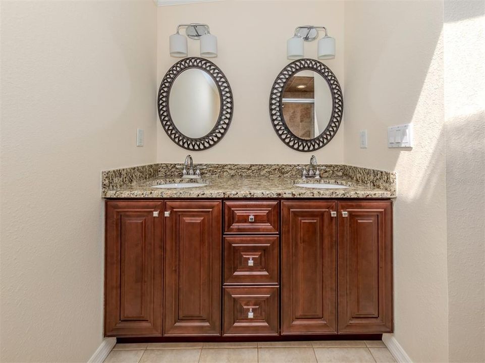 Primary bath vanity with granite counter and dual sinks.