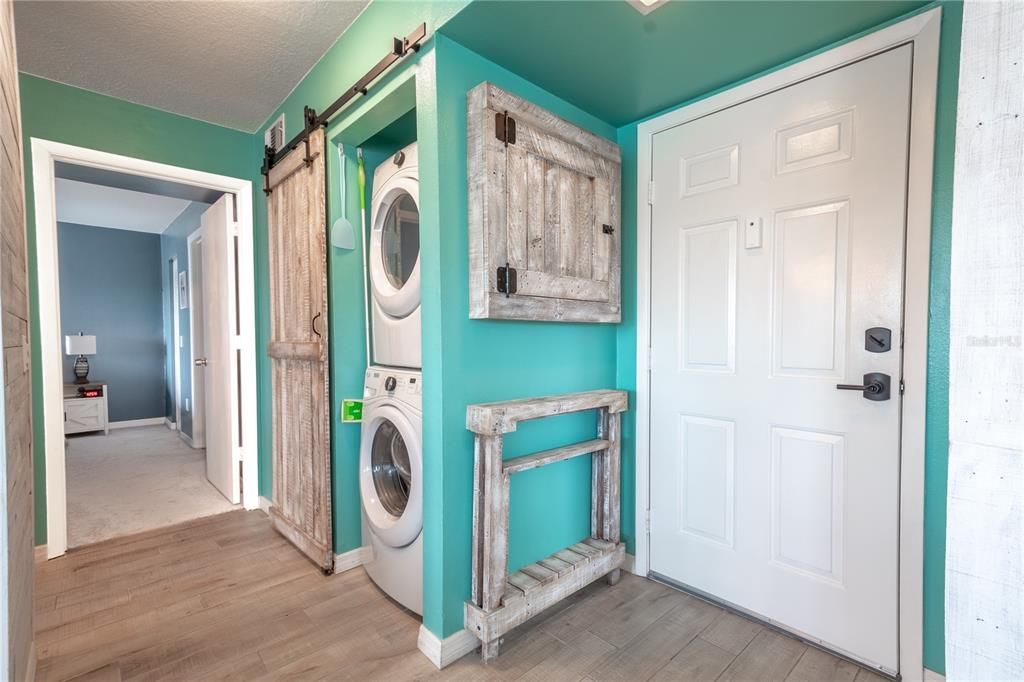 The unit features a closet stackable washer and dryer with a stylish barn door.