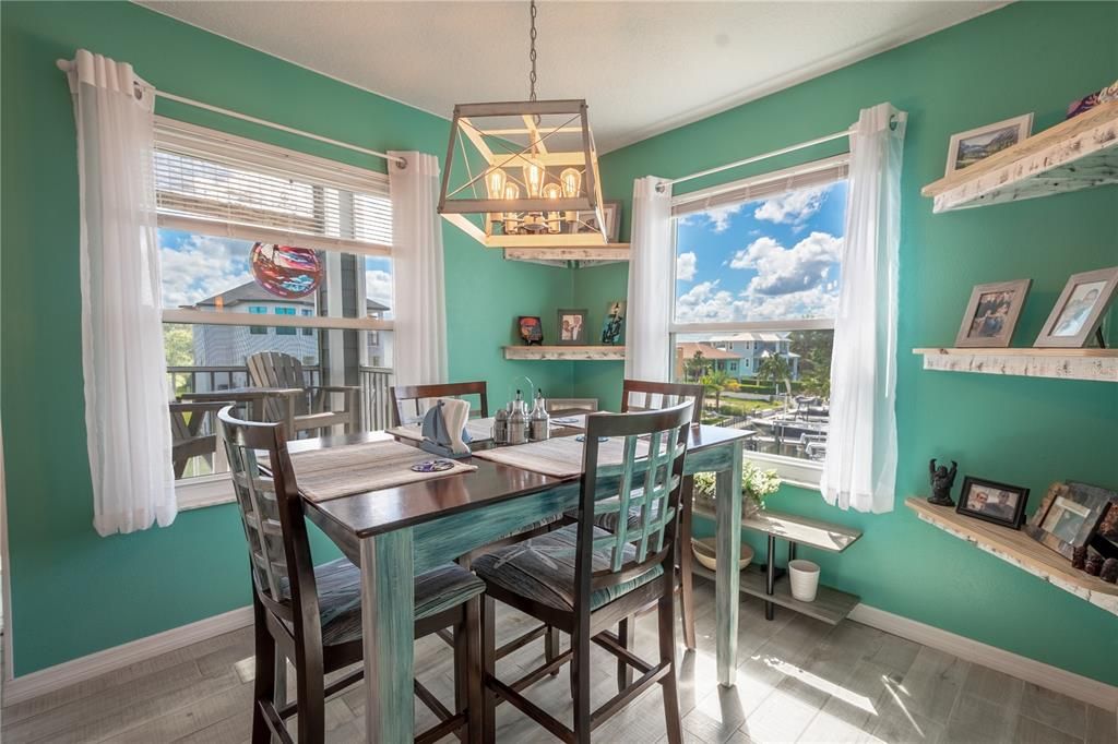 The dining room is illuminated by a coastal industrial chandelier exuding a comforting glow.