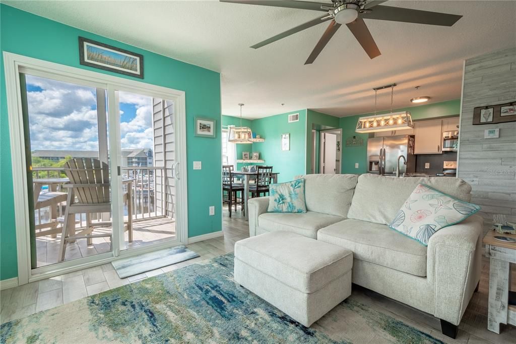 The living room is open to the balcony, the kitchen and dining area.