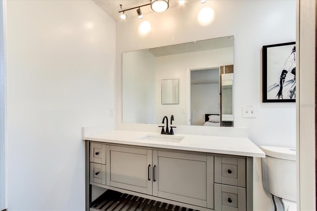 Primary bathroom ensuite with new cabinets and lighting.