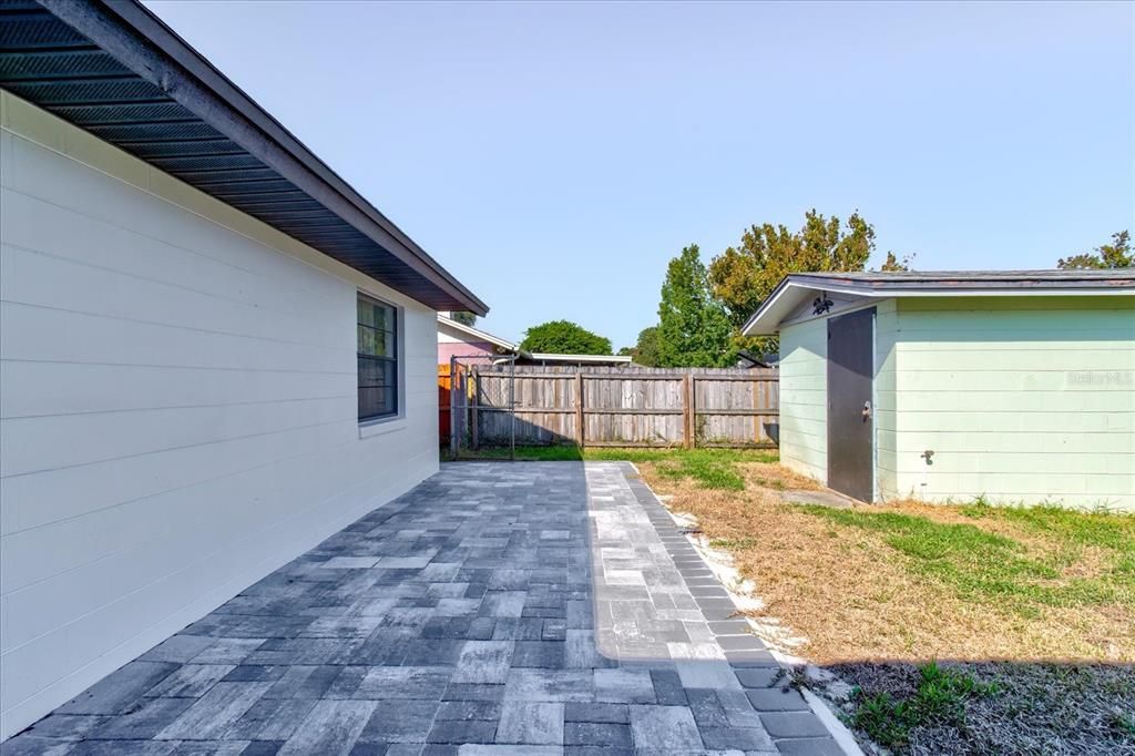 View of newly added backyard patio and additional storage building.