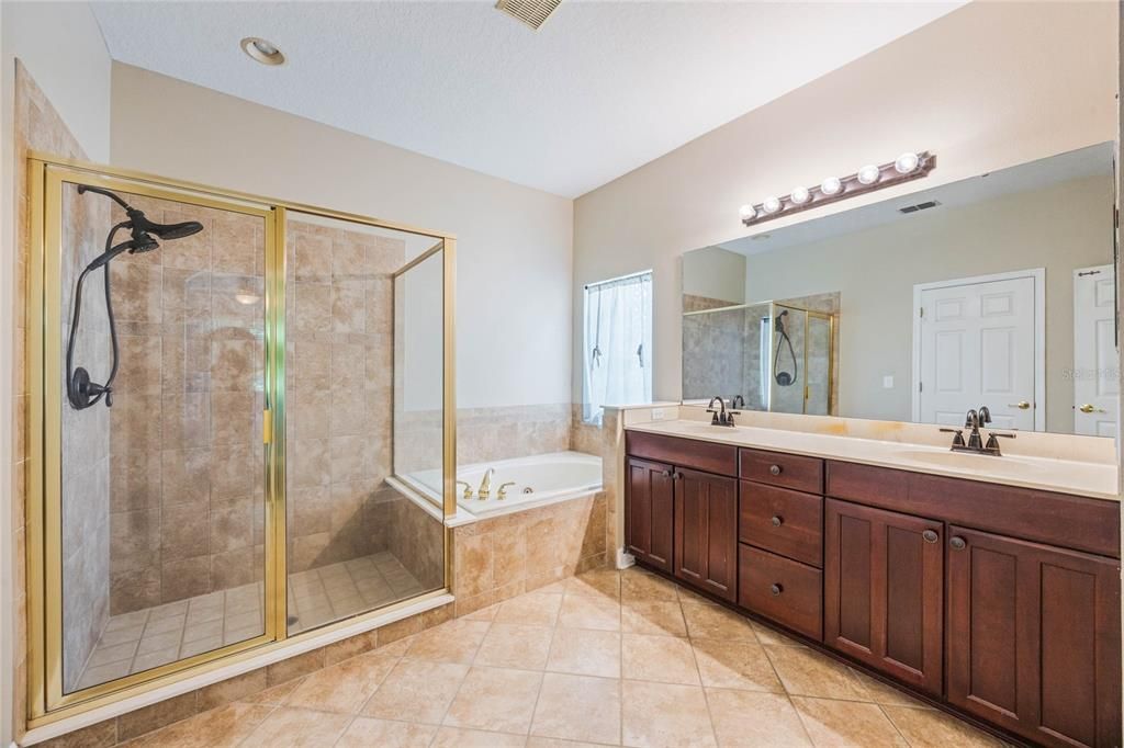 Primary en-suite bath includes double vanity, large walk-in shower and garden tub.