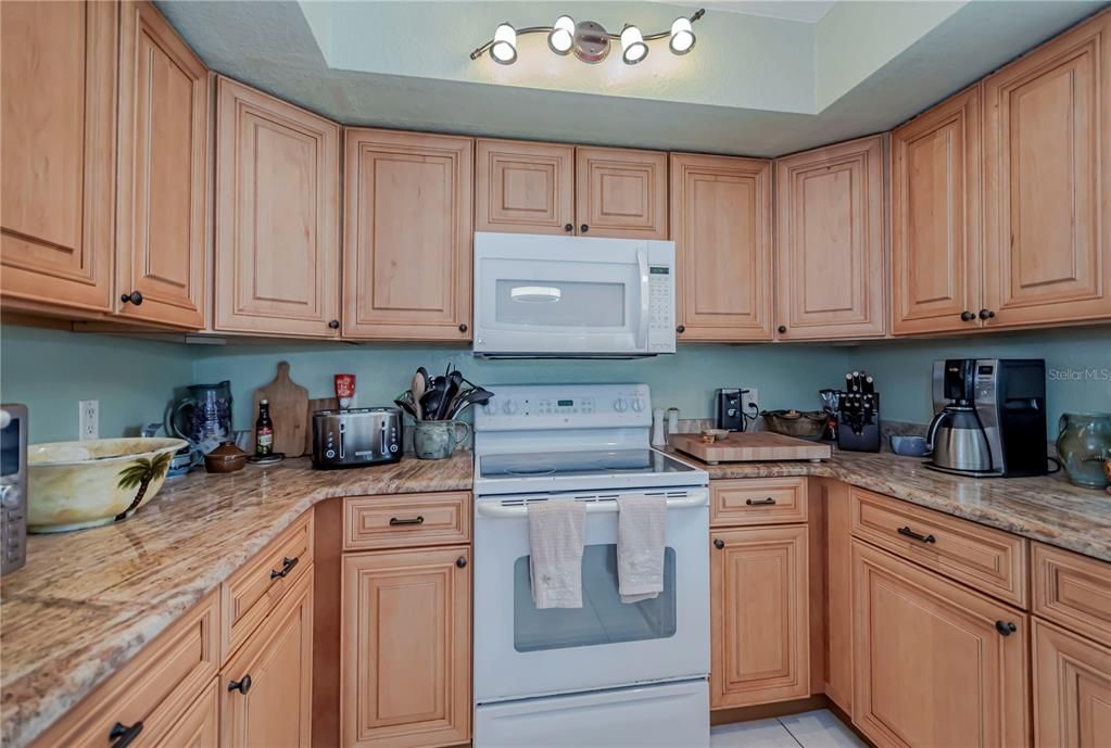 Wood cabinetry and granite counter tops in this bright and cheerful kitchen.