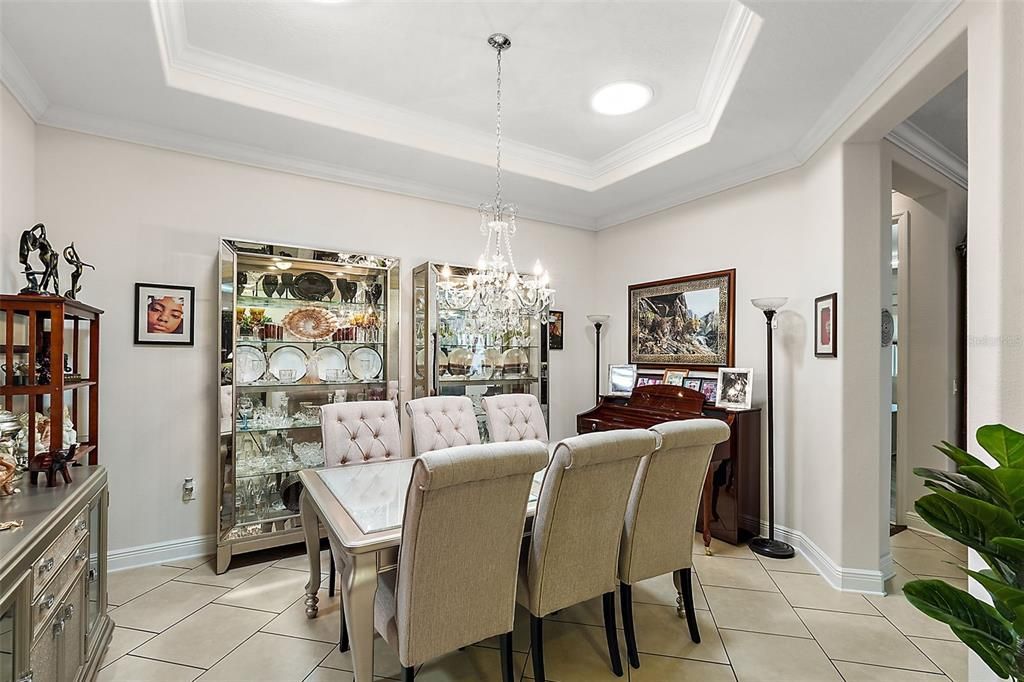 Off of the Foyer's Corridor you find an Elegant Formal Dining Room, with Crown Molding wit twinkle lights. Two Solar Panels to bring in the sunlight. lovely Arch Ways through the Faoyer lead you to different rooms.