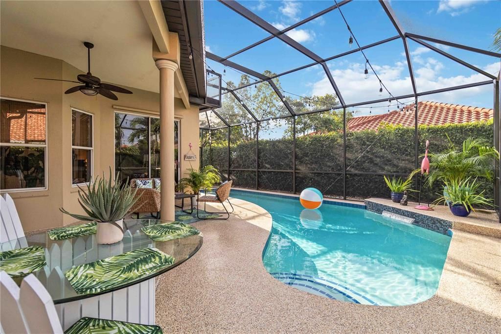 Overview of the caged pool area with a ceiling fan.