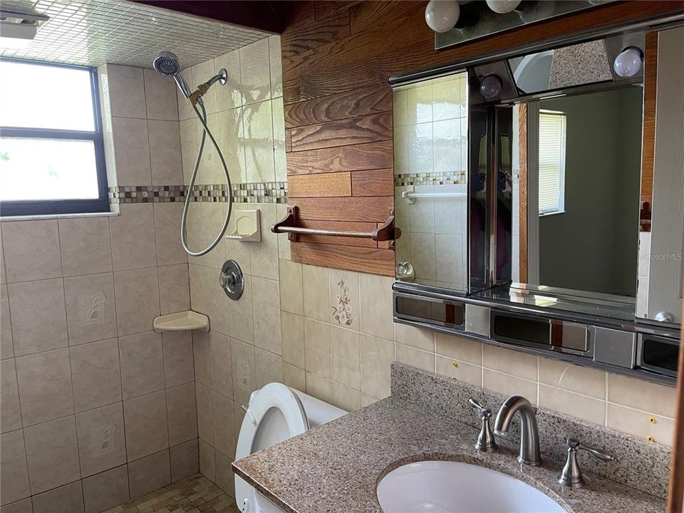 The bathroom features a window and a walk-in shower.