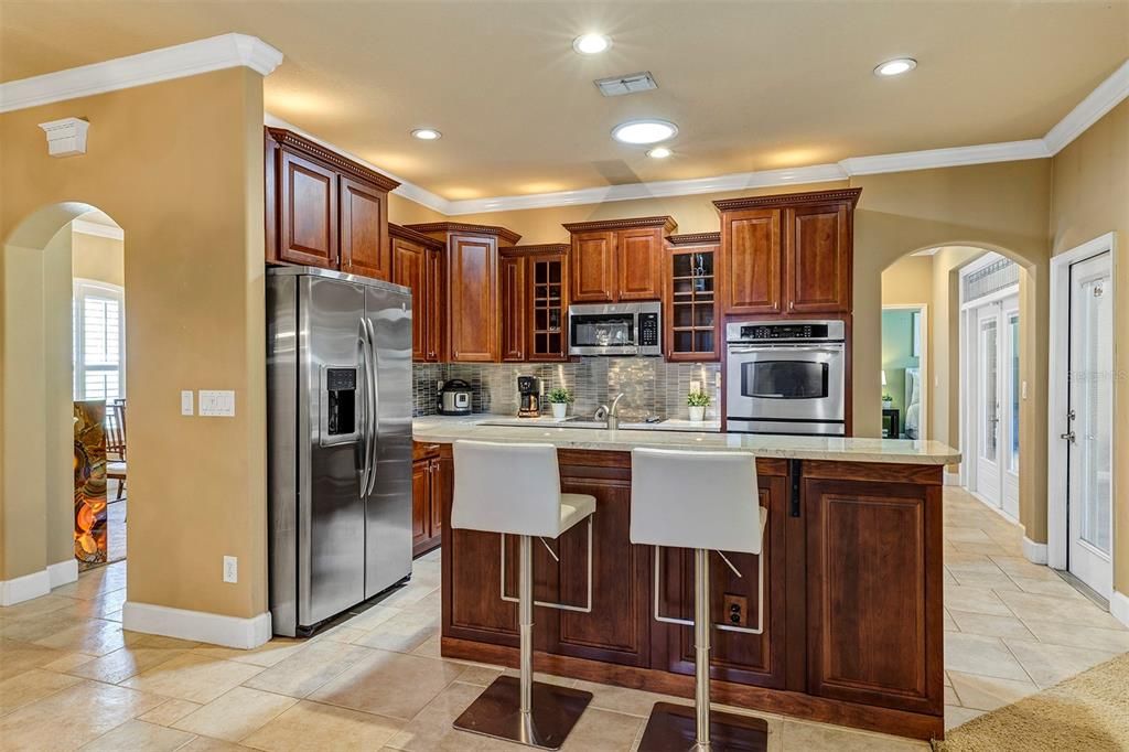 Gourmet kitchen with quartz countertops overlooks family room and dinette area