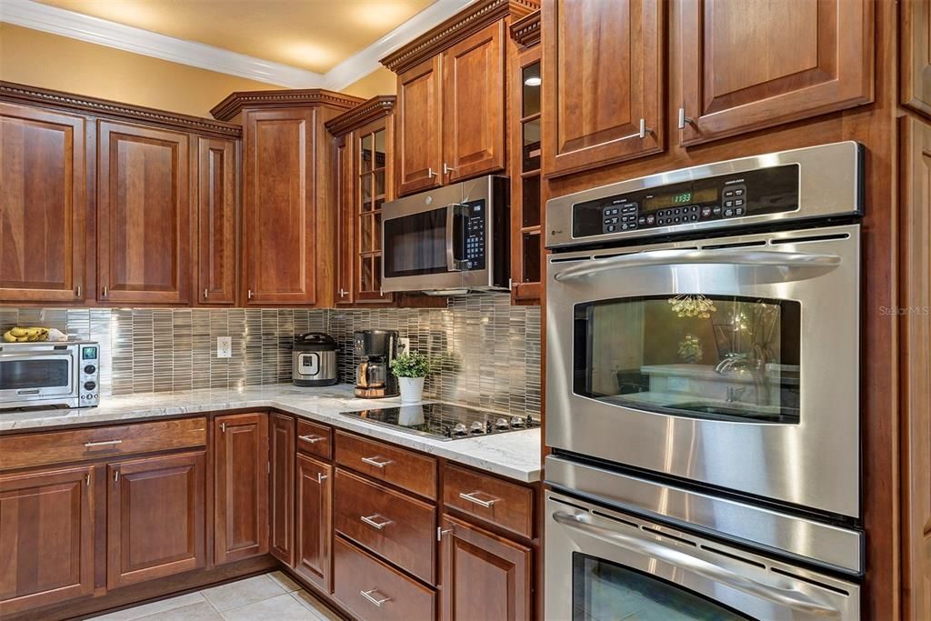 Gourmet kitchen with Cherry cabinets, double oven, quartz countertops overlooks family room and dinette area