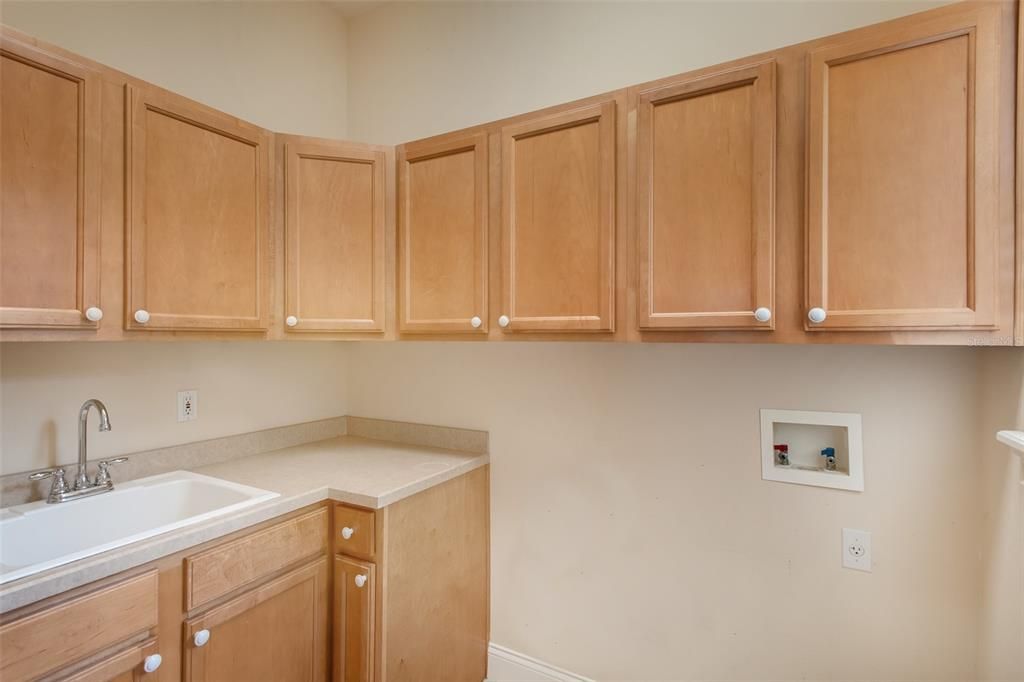 Separate laundry room with sink and cabinets