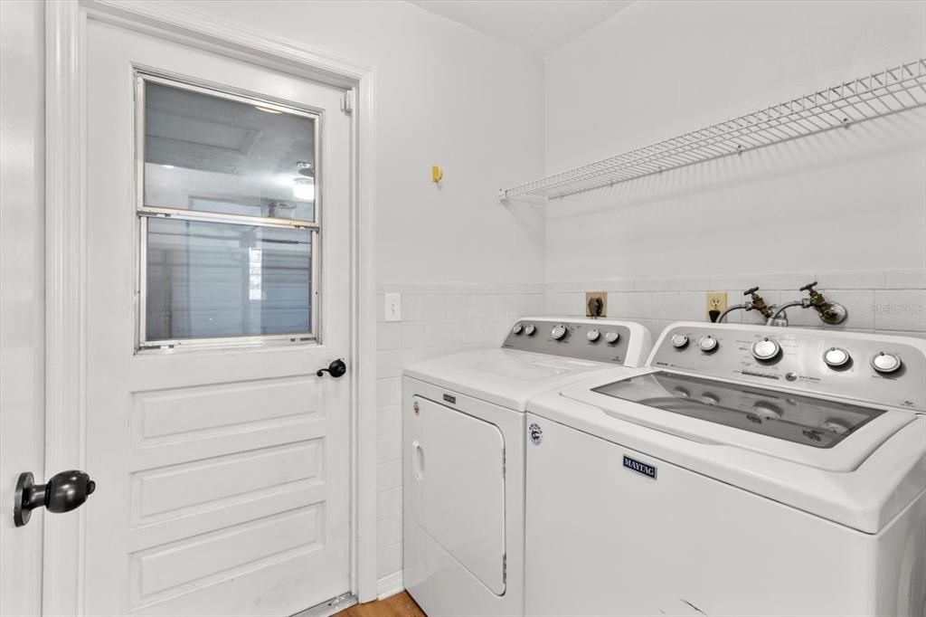 Laundry Room w/ Tiled Half Wall & Door Leading to Garage