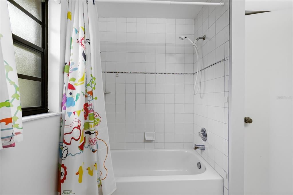 Hall bathroom with tub and shower surround