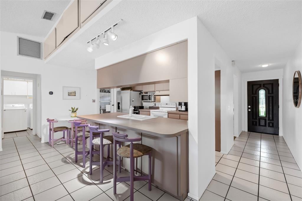 View of kitchen to foyer and front door