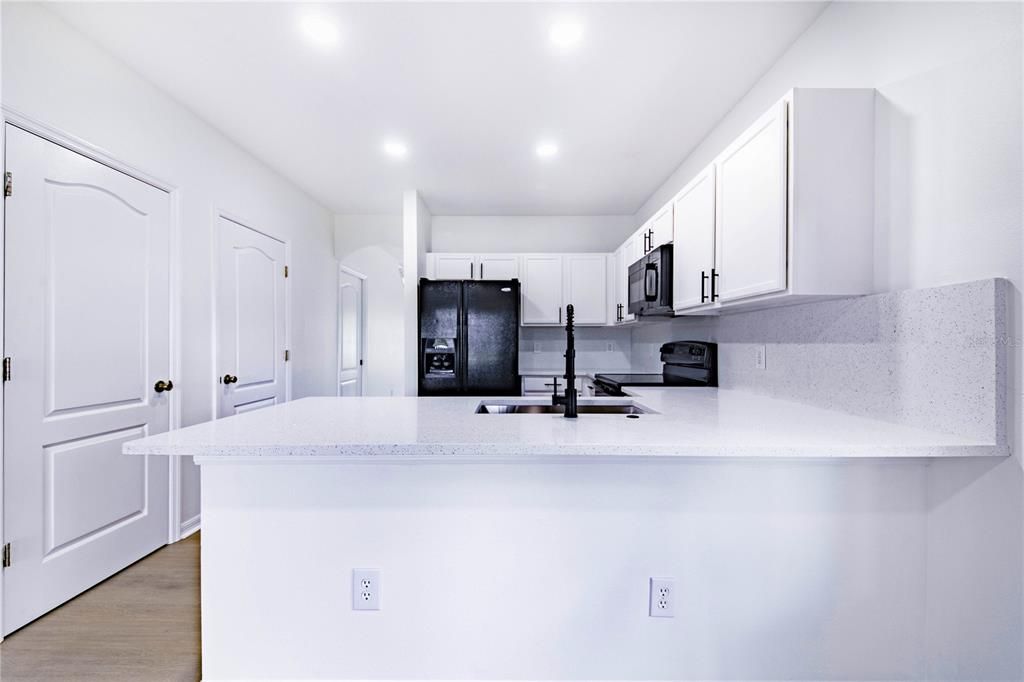 Breakfast bar with Quartz countertops and matching slab back splash