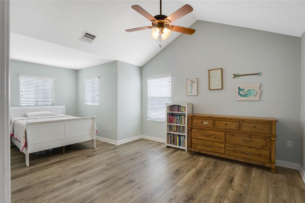 Huge guest bedroom with lvp floors and vaulted ceilings