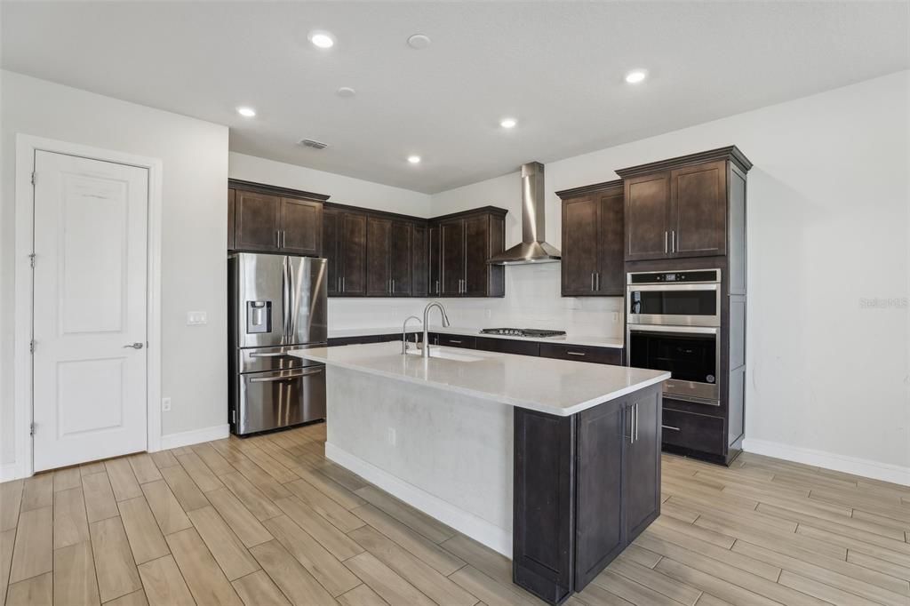 The family chef will feel at home surrounded by rich solid wood cabinetry, UPGRADED STAINLESS STEEL APPLIANCES that include a GAS STOVE, stone counters, a large ISLAND with breakfast bar seating and a walk-in pantry for ample storage.