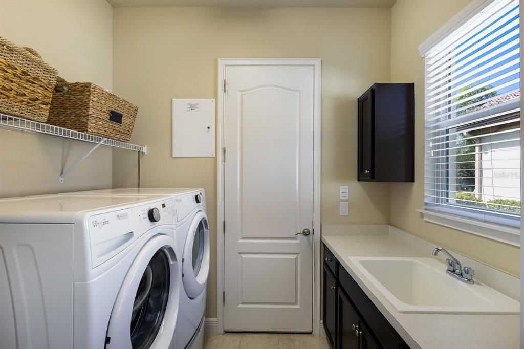 Laundry room with sink and cabinet storage