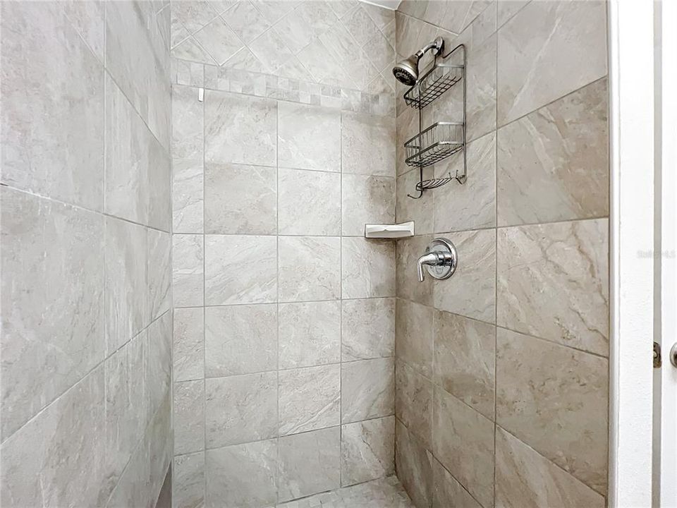 Tiled walk in shower in primary bathroom