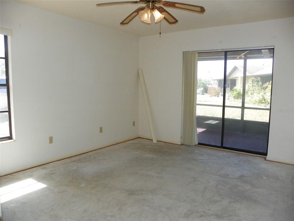 Guest bedroom with entry to second covered/screened lanai area.