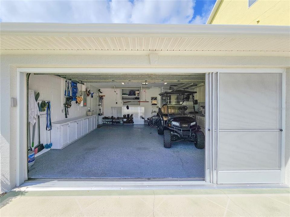 Sliding screen doors on garage allow air flow in the space.