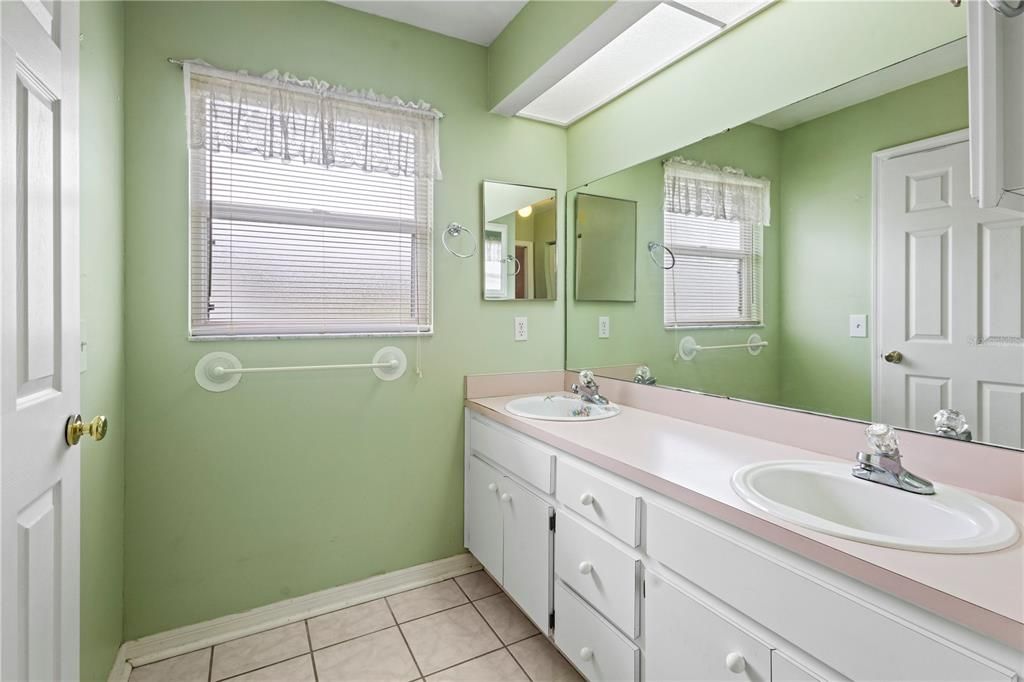 Primary en-suite bathroom with dual sink vanity