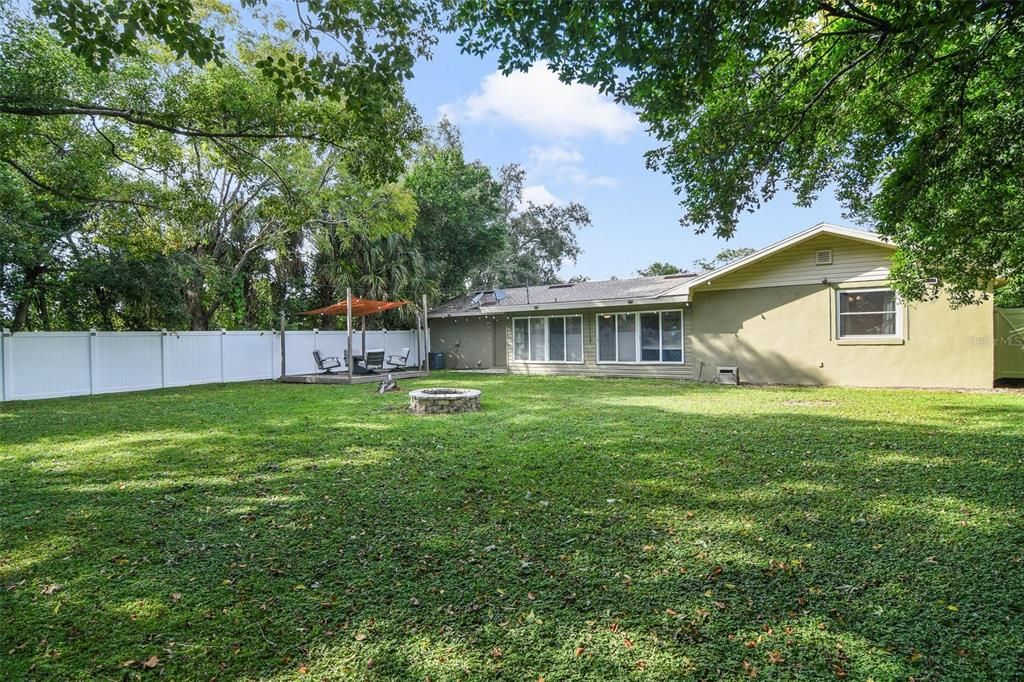 The expansive front and back yards are surrounded by mature trees creating a park-like setting to entertain family on the recently painted deck or gather with friends around the fire pit.