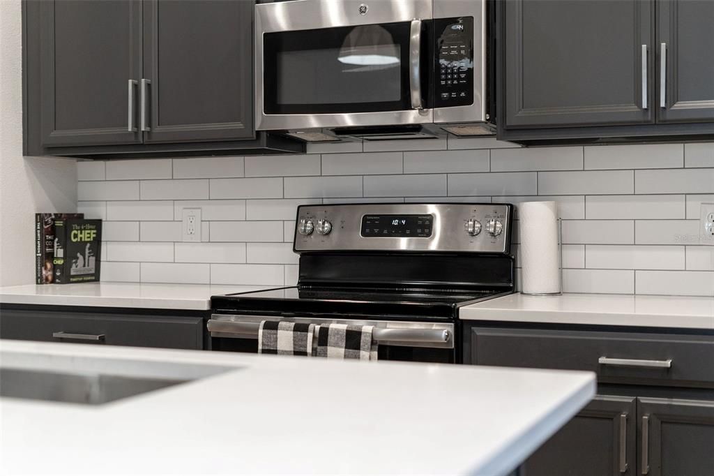 Kitchen range with overhead microwave.